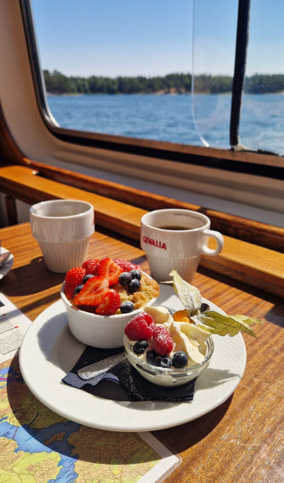Äppelpaj med färska bär och grädde och havsutsikt ombord på MS Strömma kanal
