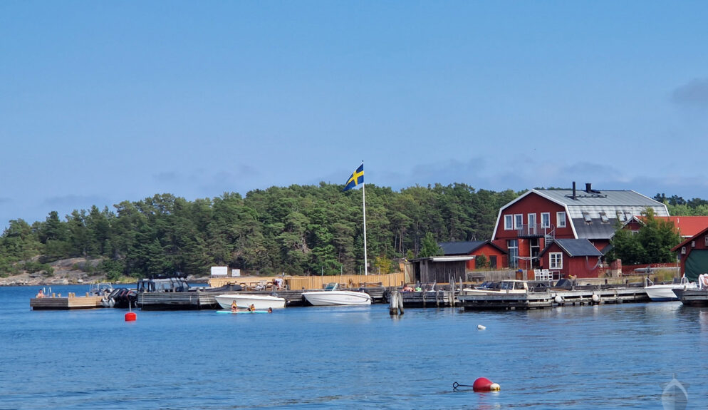 Båtar, badare och röda hus på Sandön/Sandhamn
